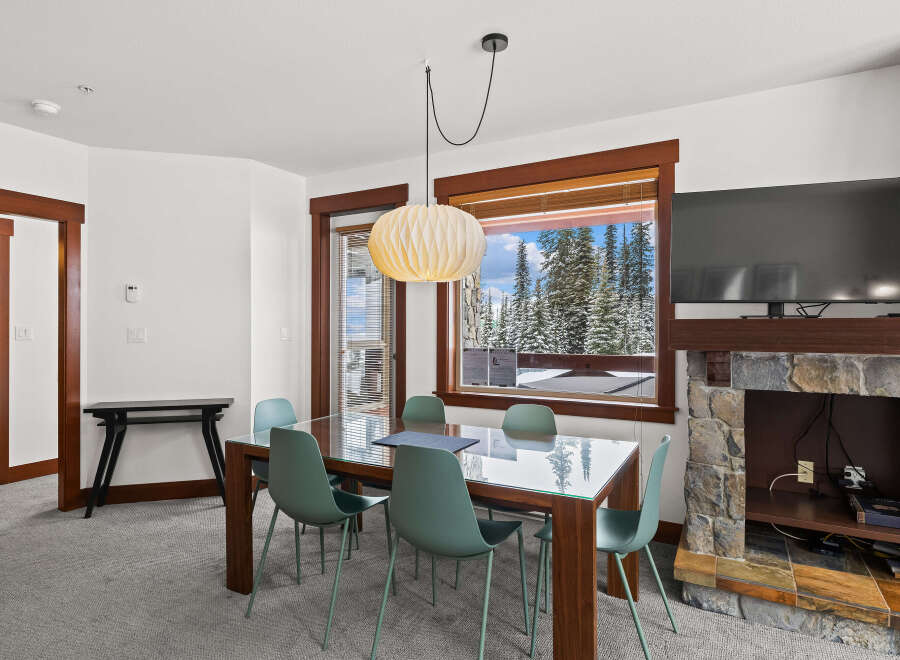This stunning property features a modern dining area with a glass-top table and stylish chairs.