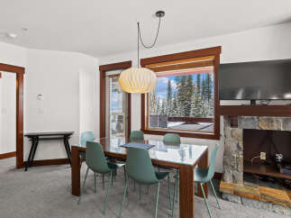 This stunning property features a modern dining area with a glass-top table and stylish chairs.