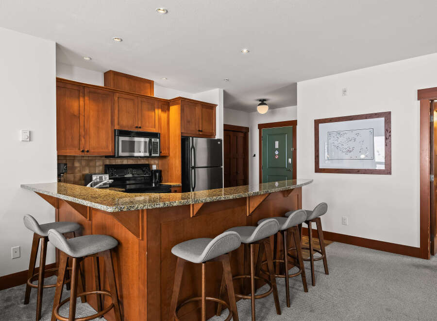 This stunning kitchen features a beautiful breakfast bar with seating, perfect for casual dining or entertaining.