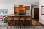 This stunning kitchen boasts beautiful wooden cabinetry, a sleek stainless steel refrigerator, and a convenient microwave.