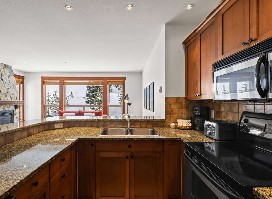 Step into this stunning kitchen, boasting elegant wooden cabinetry and a sleek black stovetop.