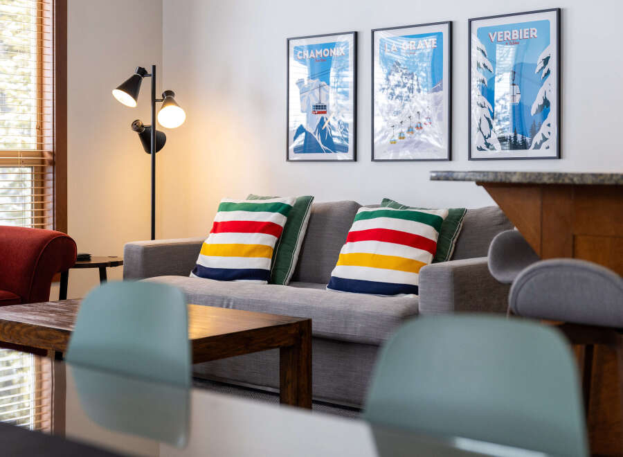 This cozy living space features a comfortable gray sofa adorned with colorful striped pillows, creating a welcoming atmosphere.