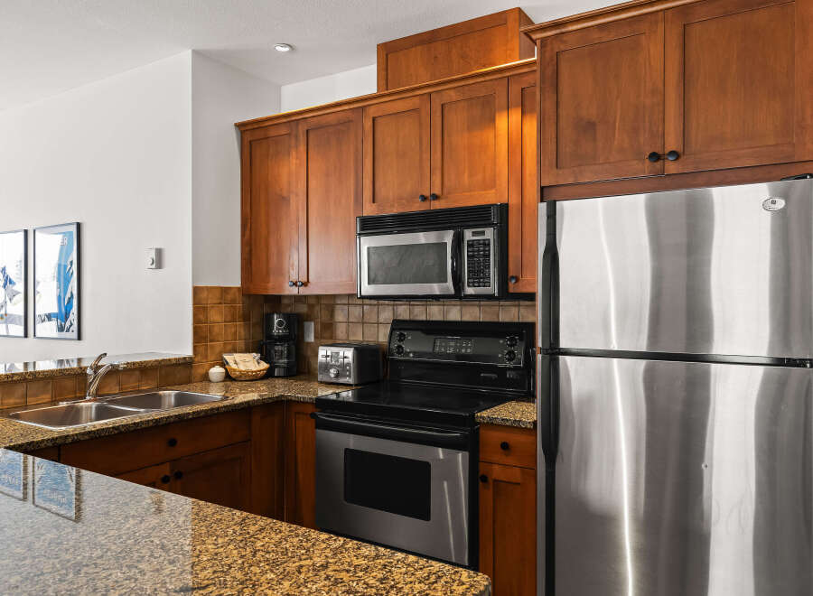 This stunning kitchen boasts beautiful wooden cabinetry and modern stainless steel appliances, creating a warm and inviting atmosphere.