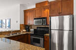 This stunning kitchen boasts beautiful wooden cabinetry and modern stainless steel appliances, creating a warm and inviting atmosphere.