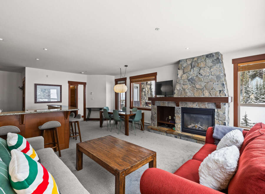 This stunning property boasts a cozy living room with a stone fireplace, perfect for relaxing evenings.