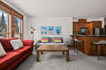 This cozy living space features a vibrant red sofa, perfect for relaxing after a day on the slopes.