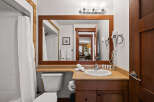 This inviting bathroom features a well-lit vanity area with a large mirror and a sleek sink.