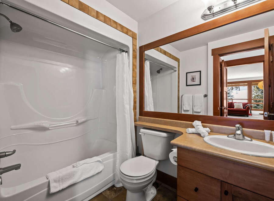 This stunning bathroom features a modern design with a sleek white bathtub and shower.