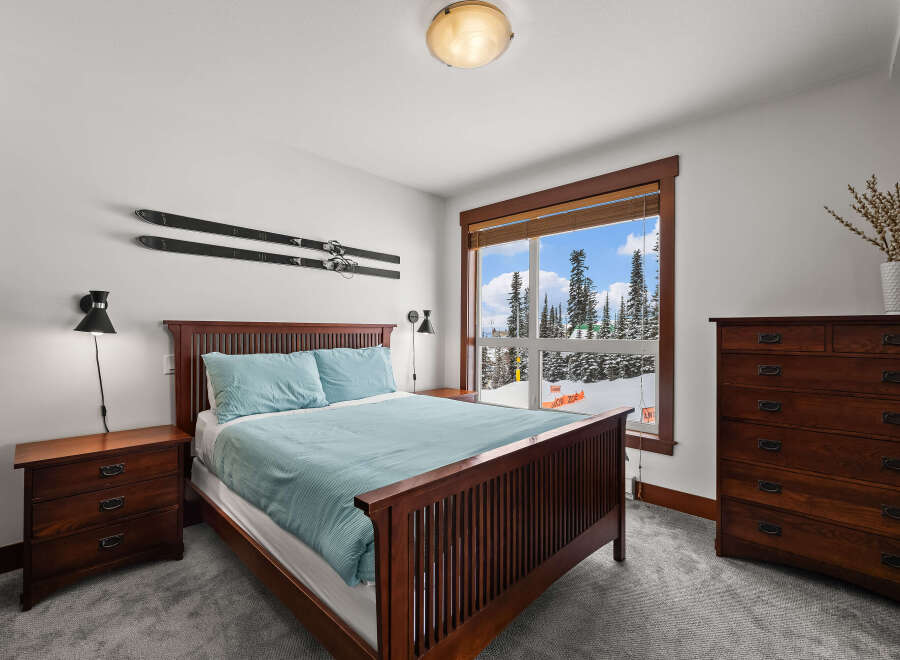 This cozy bedroom features a beautiful wooden bed frame and matching nightstands, creating a warm and inviting atmosphere.