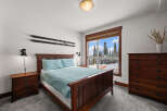 This cozy bedroom features a beautiful wooden bed frame and matching nightstands, creating a warm and inviting atmosphere.