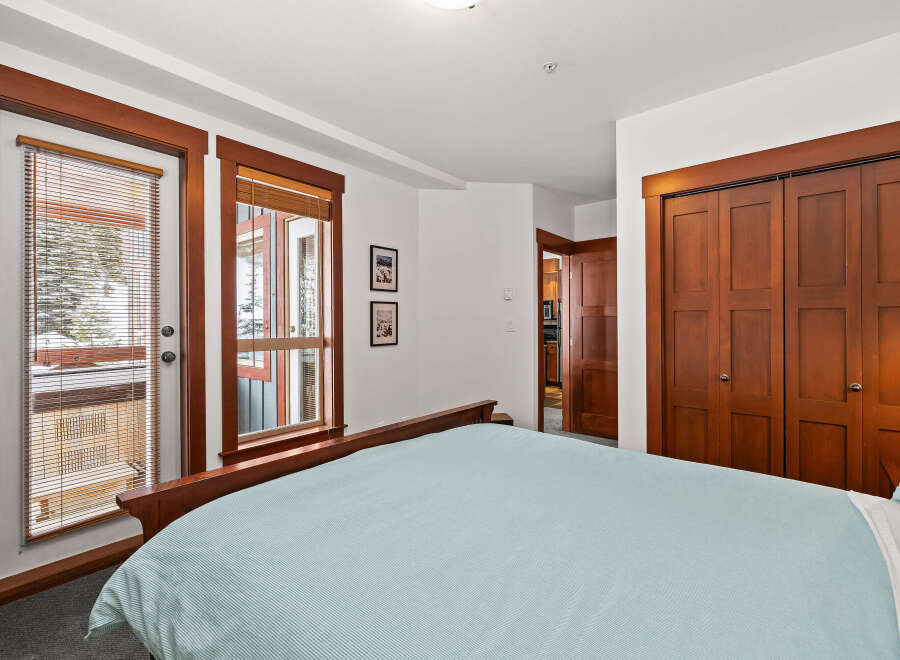 This cozy bedroom features a comfortable bed with a light blue striped comforter, perfect for a relaxing night's sleep.