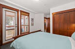 This cozy bedroom features a comfortable bed with a light blue striped comforter, perfect for a relaxing night's sleep.