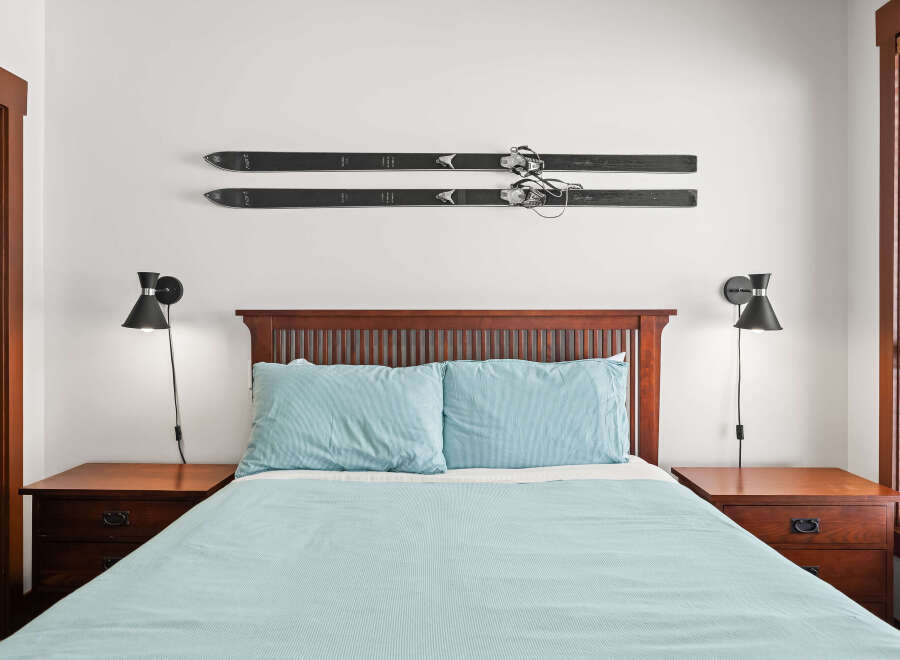 This cozy bedroom features a comfortable bed with light blue bedding, perfect for a relaxing retreat.