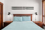 This cozy bedroom features a comfortable bed with light blue bedding, perfect for a relaxing retreat.