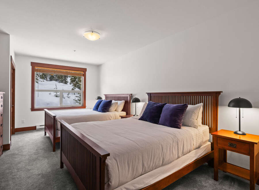 This cozy bedroom features two comfortable beds with plush pillows, perfect for a relaxing stay.