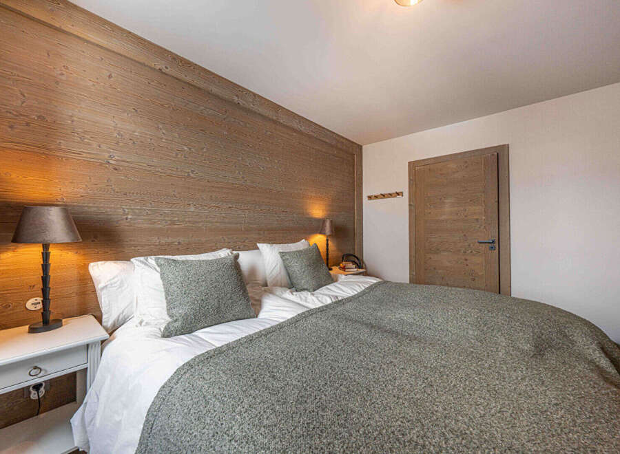 This cozy bedroom features a stunning wooden accent wall, creating a warm and inviting atmosphere.