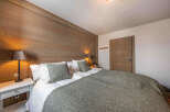 This cozy bedroom features a stunning wooden accent wall, creating a warm and inviting atmosphere.