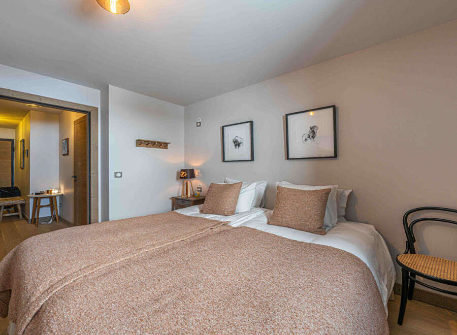 This cozy bedroom features two twin beds with warm-toned bedding, perfect for a comfortable stay.
