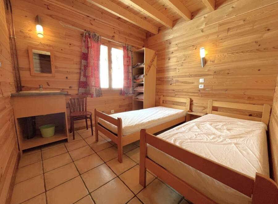 Discover the charm of this cozy bedroom featuring wooden walls and a warm, inviting atmosphere.
