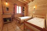 Discover the charm of this cozy bedroom featuring wooden walls and a warm, inviting atmosphere.