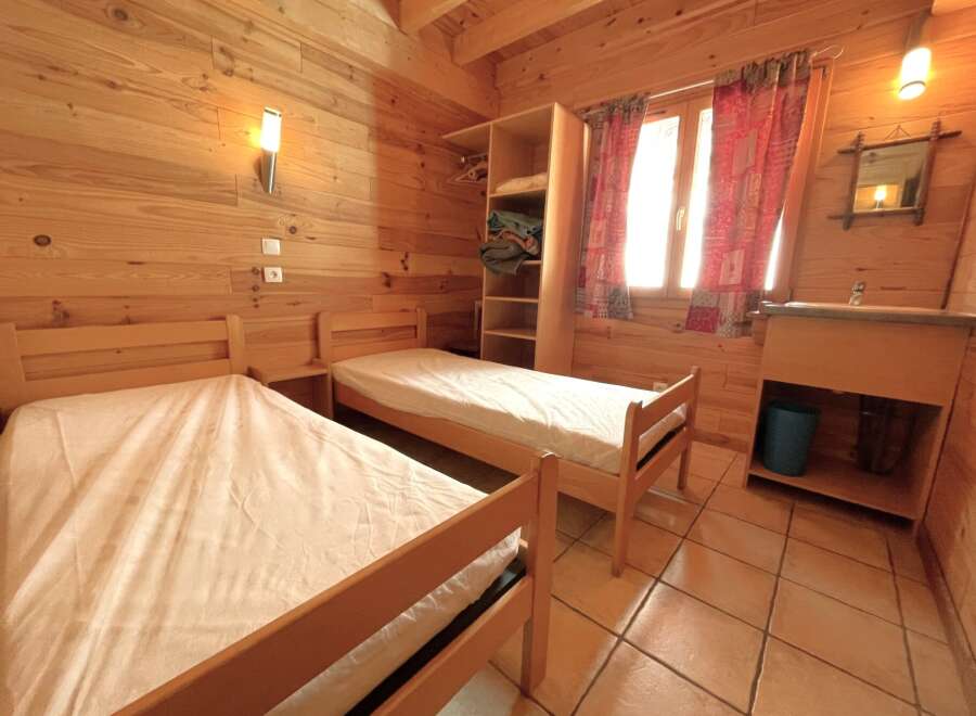This cozy cabin bedroom features two twin beds, perfect for a comfortable stay.