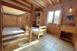 This cozy cabin bedroom features a charming wooden interior, perfect for a rustic retreat.