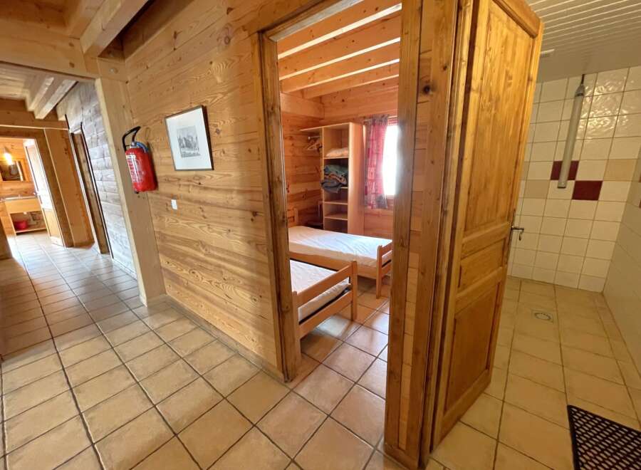 Step into this charming property featuring a cozy bedroom with wooden accents and a comfortable bed.