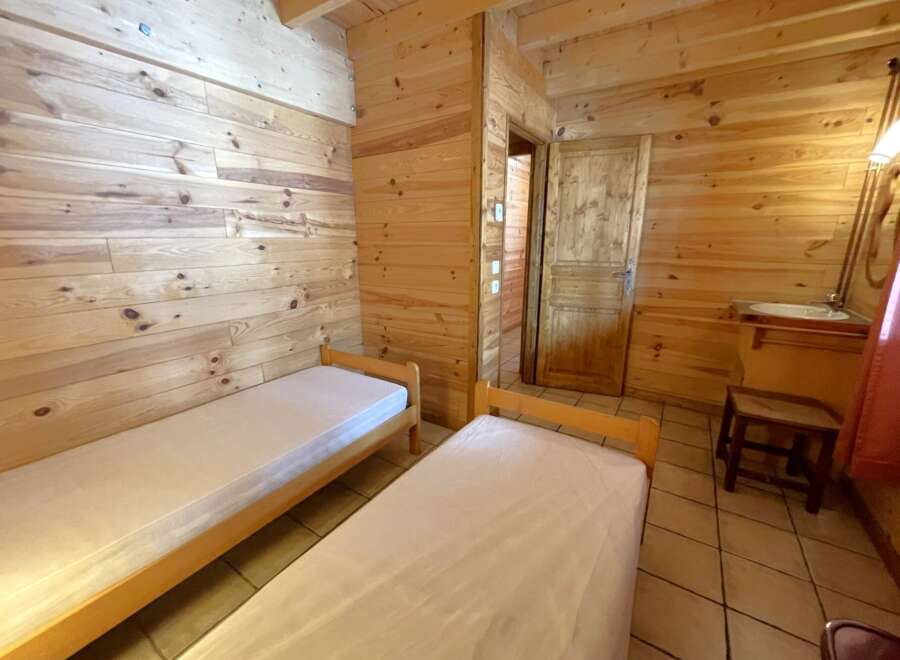 Discover the charm of this cozy cabin featuring two comfortable beds, perfect for a relaxing getaway.