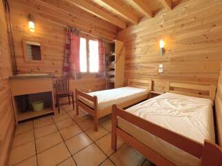 Discover the charm of this cozy bedroom featuring wooden walls and a warm, inviting atmosphere.