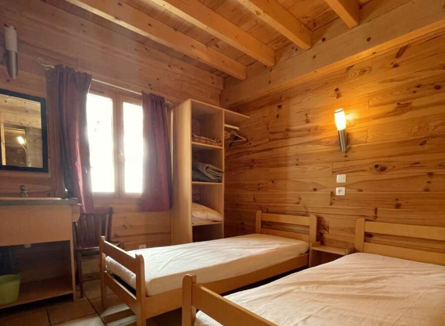 This cozy bedroom features wooden walls and ceilings, creating a warm and inviting atmosphere.