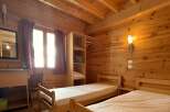 This cozy bedroom features wooden walls and ceilings, creating a warm and inviting atmosphere.