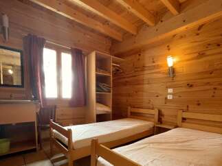 This cozy bedroom features wooden walls and ceilings, creating a warm and inviting atmosphere.