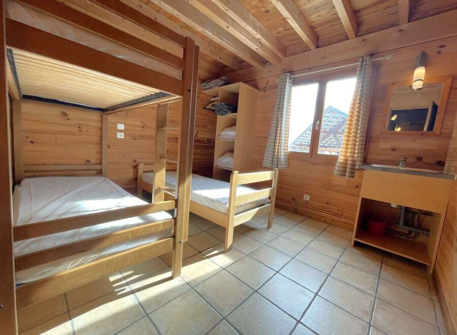 This cozy cabin bedroom features a charming wooden interior, perfect for a rustic retreat.