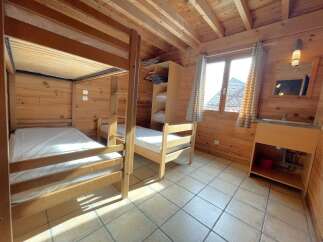 This cozy cabin bedroom features a charming wooden interior, perfect for a rustic retreat.