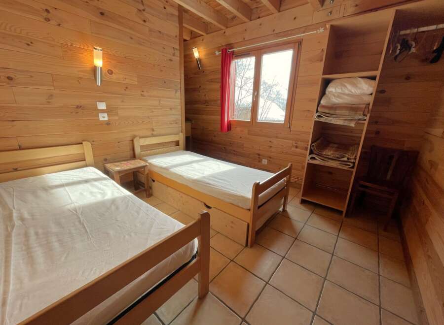 This cozy bedroom features two single beds, perfect for a comfortable stay.