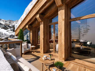 Experience luxury mountain living in this stunning chalet, featuring expansive wooden beams and floor-to-ceiling windows that offer breathtaking alpine views.
