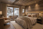Experience ultimate relaxation in this luxurious mountain retreat, featuring a cozy bedroom with a plush king-sized bed and a private balcony overlooking a snowy landscape.