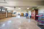 This spacious garage offers ample room for vehicles and storage, featuring a polished concrete floor and overhead lighting.