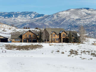 This stunning property boasts a luxurious stone exterior and sits amidst a picturesque winter landscape.