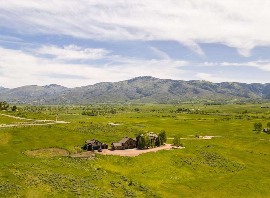 Experience luxurious mountain living on this expansive estate, featuring a stunning lodge-style home with accompanying outbuildings.
