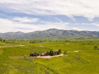 Experience luxurious mountain living on this expansive estate, featuring a stunning lodge-style home with accompanying outbuildings.