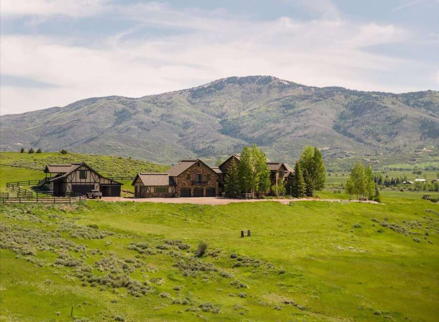Experience luxury mountain living in this stunning estate, featuring a grand stone-clad main residence and a charming guest house.