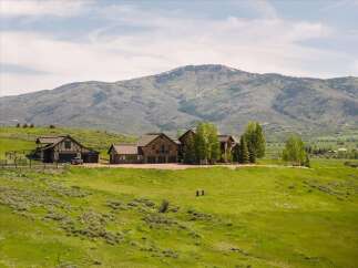 Experience luxury mountain living in this stunning estate, featuring a grand stone-clad main residence and a charming guest house.
