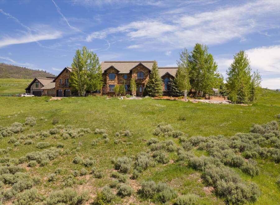 Experience luxury mountain living in this stunning stone estate, nestled on a sprawling hillside with panoramic views.