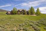 Experience luxury mountain living in this stunning stone estate, nestled on a sprawling hillside with panoramic views.
