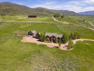 Discover this stunning mountain estate featuring a luxurious stone-clad main residence and a charming adjacent barn.