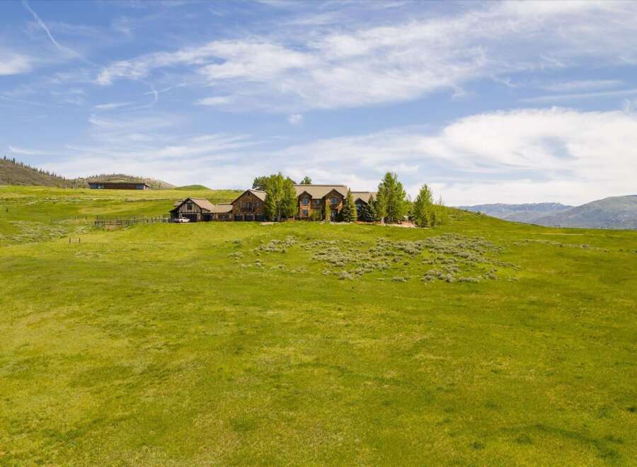 Experience luxury living in this expansive estate, nestled on a sprawling green hillside with breathtaking mountain views.