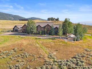 Nestled in a picturesque landscape, this expansive estate offers a luxurious stone-clad residence with multiple wings and a charming Tudor-style guest house.