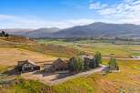 Experience luxury living in this stunning mountain estate, featuring a grand stone-clad residence with multiple garages and a charming guesthouse.
