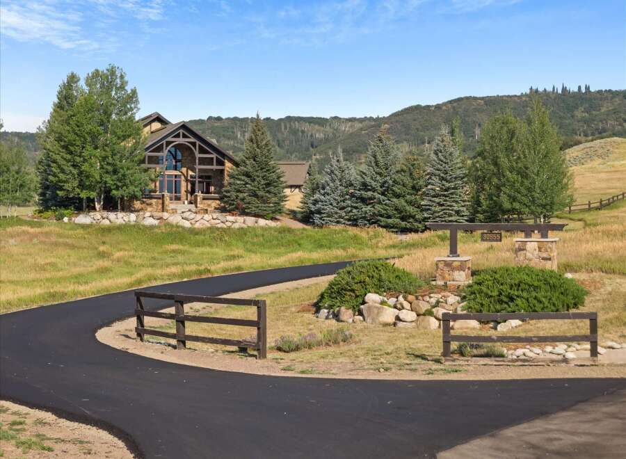 Discover this stunning mountain home featuring a grand stone facade and expansive windows that capture breathtaking views.